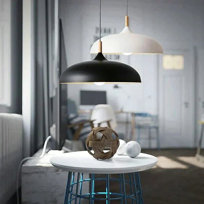 Schwarze und weiße Pendelleuchten über modernem Tisch mit Dekoration im skandinavischen Design.