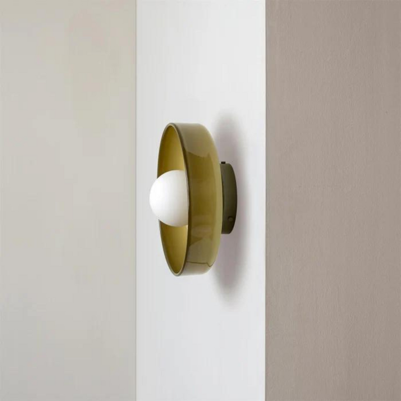 Moderne Wandleuchte aus grünem Glas mit weißem Leuchtmittel, minimalistisches Design.