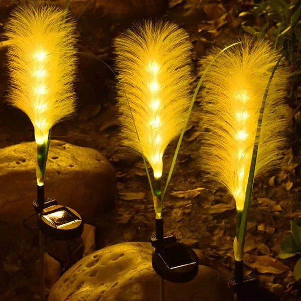 Solarbetriebene LED-Gartenleuchten in Federform, warmweiß, dekorative Außenbeleuchtung.