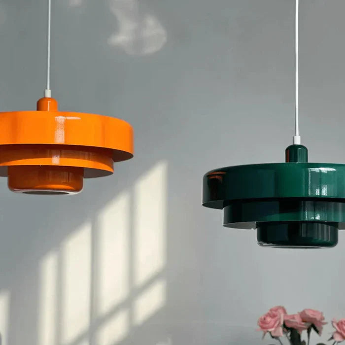 Zwei moderne Hängelampen, orange und grün, aus Metall, im skandinavischen Design.