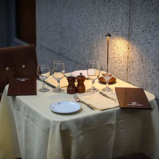 Eleganter Restauranttisch mit Weingläsern, Speisekarten und Tischlampe, ideal für Abendessen.