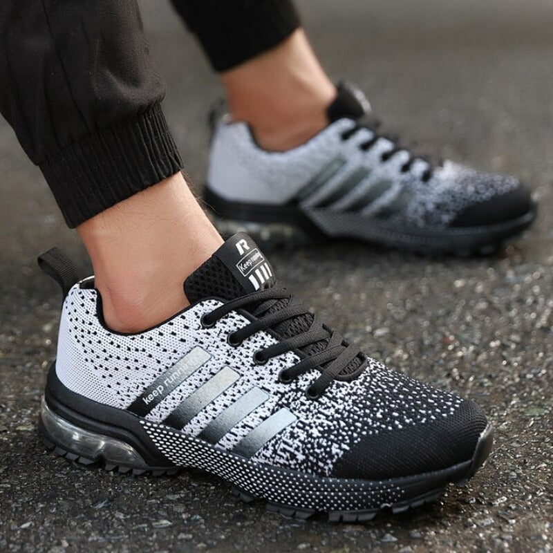 Schwarz-weiße Sportschuhe mit Luftpolstersohle, atmungsaktiv, ideal für Laufen und Fitness.