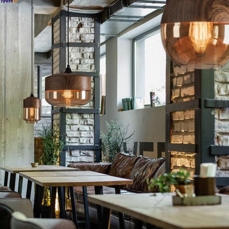 Moderne Café-Innenraum mit hölzernen Pendelleuchten und industriellem Design.