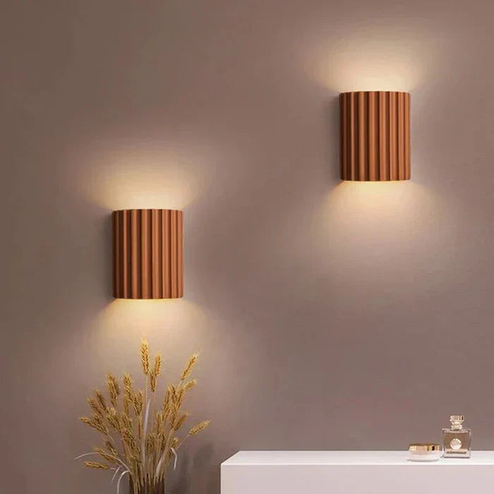 Zwei moderne, braune Wandleuchten aus Holz an grauer Wand, dekorative Beleuchtung.