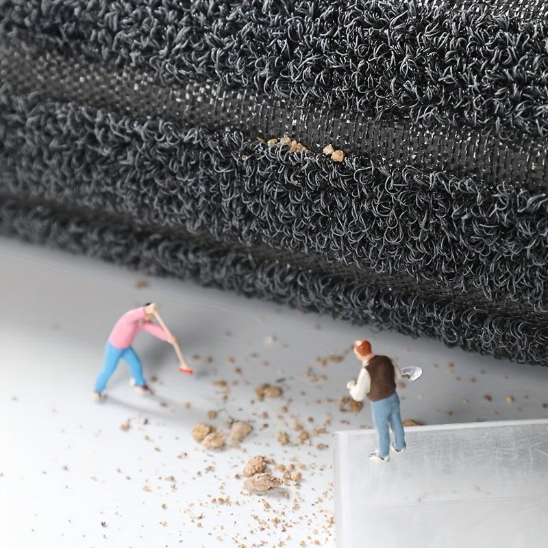 Miniaturfiguren reinigen schwarzen Teppich, Nahaufnahme, Detailansicht, Modellbau, Staubentfernung.