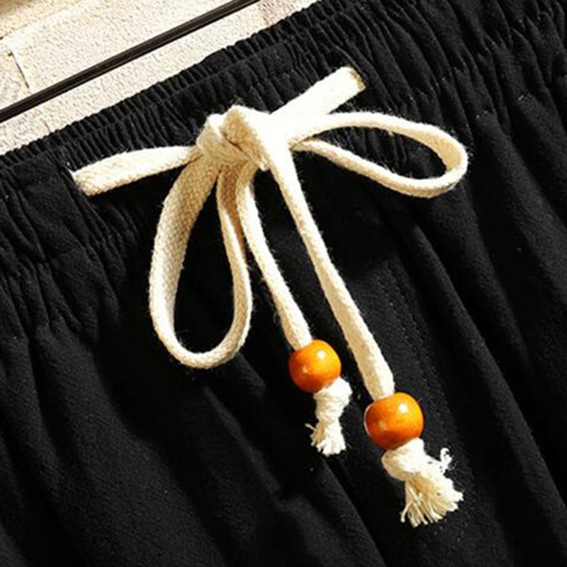 Schwarze Baumwollhose mit weißem Kordelzug und Holzperlen, lässige Sommermode.