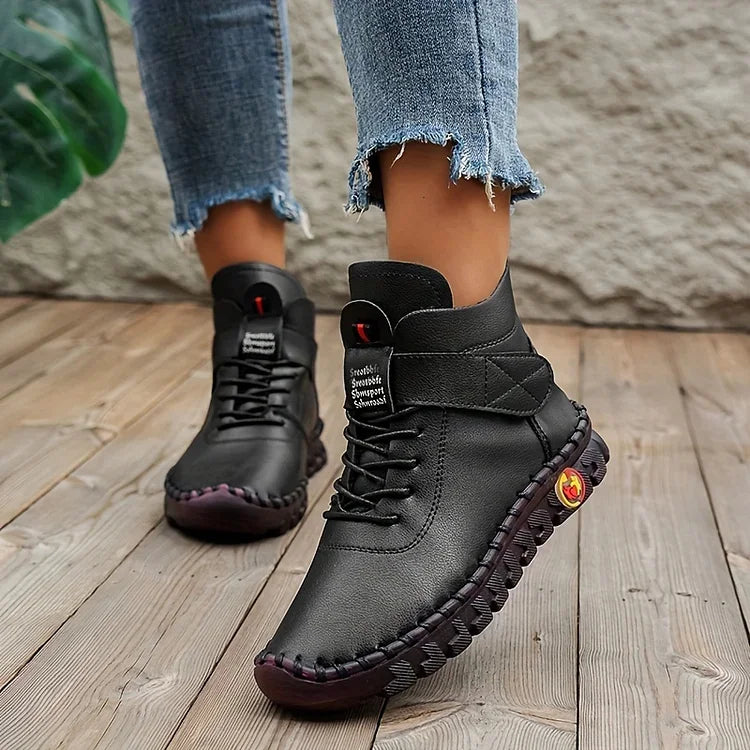 Schwarze Lederstiefel für Damen, lässig, mit Schnürung, auf Holzboden, modisch, bequem.