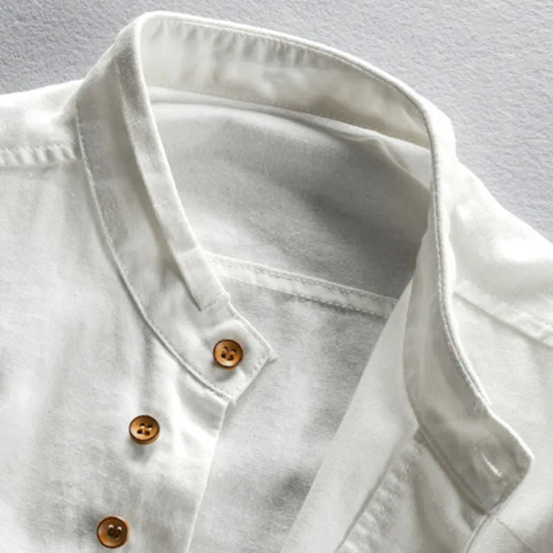 Weißes Leinenhemd mit Stehkragen und braunen Knöpfen, elegantes Design, Herrenmode.