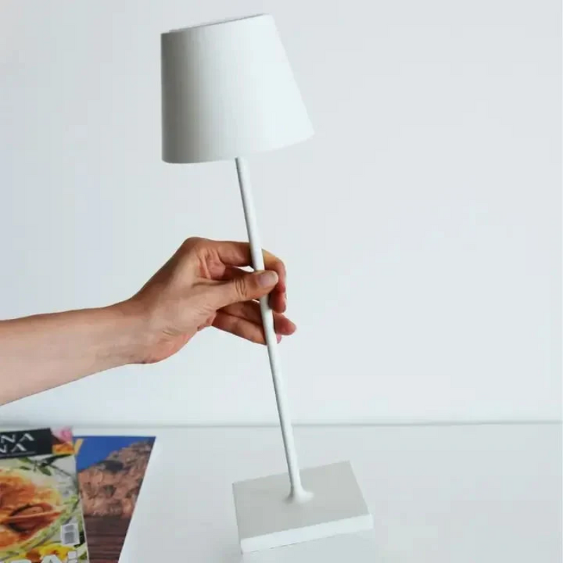 Hand hält weiße Tischlampe, modernes Design, minimalistisch, Wohnzimmerbeleuchtung.
