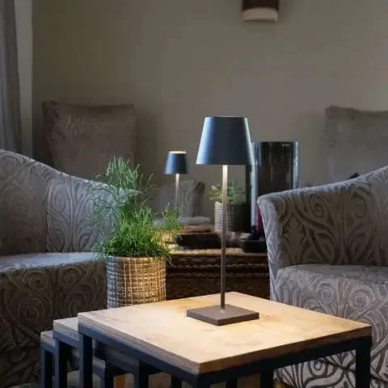 Moderne schwarze Tischlampe auf Holztisch, Wohnzimmer, stilvolle Beleuchtung, Inneneinrichtung.