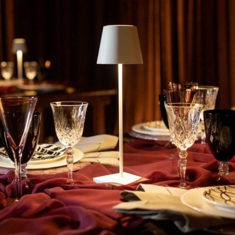 Elegante Tischlampe auf gedecktem Tisch mit Kristallgläsern und violettem Tischtuch.