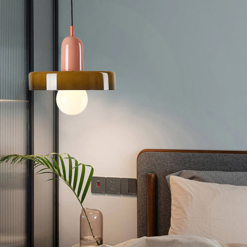 Moderne Hängelampe aus Glas und Metall über Bett, warmes Licht, Schlafzimmerbeleuchtung.