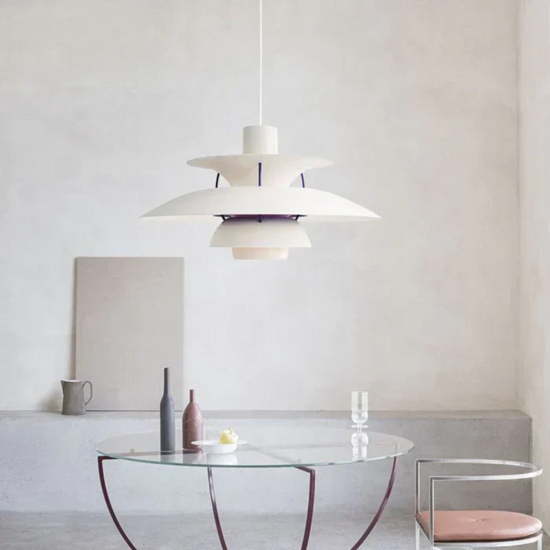 Moderne weiße Pendelleuchte über rundem Glastisch in minimalistischem Wohnzimmer.