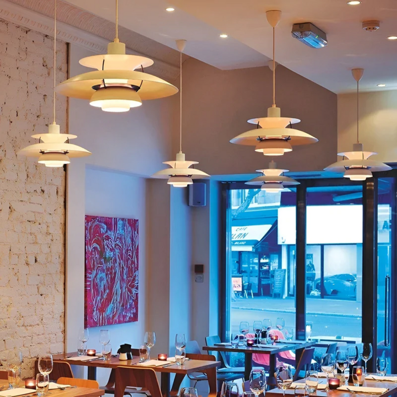 Moderne weiße Pendelleuchten im Restaurant, skandinavisches Design, elegante Innenbeleuchtung.