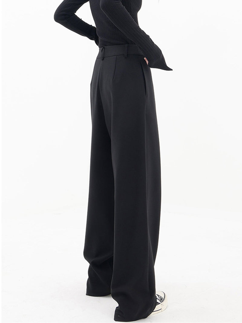 Frau trägt schwarze, asymmetrische Baggy-Hose, modisch, elegant, Damenmode, Streetwear.