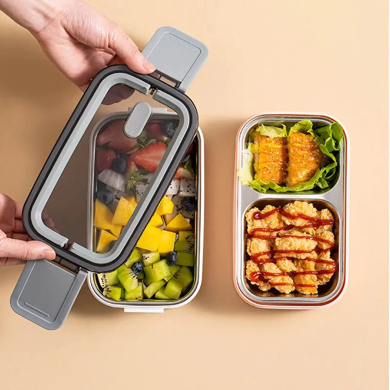Zwei Bento-Boxen mit Obst und paniertem Hähnchen, transparentem Deckel, ideal für Mahlzeiten unterwegs.