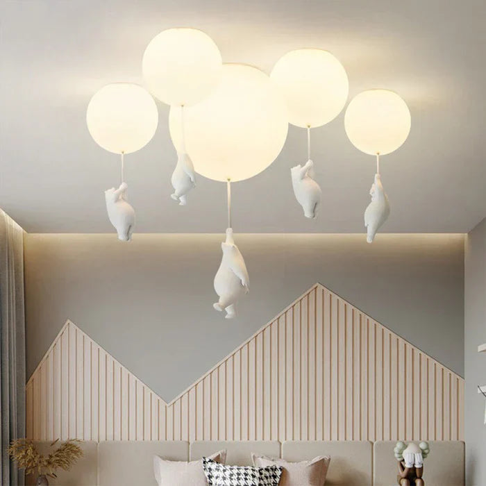 Moderne Deckenleuchte mit weißen Kugeln und hängenden Figuren, ideal für Wohnzimmerbeleuchtung.