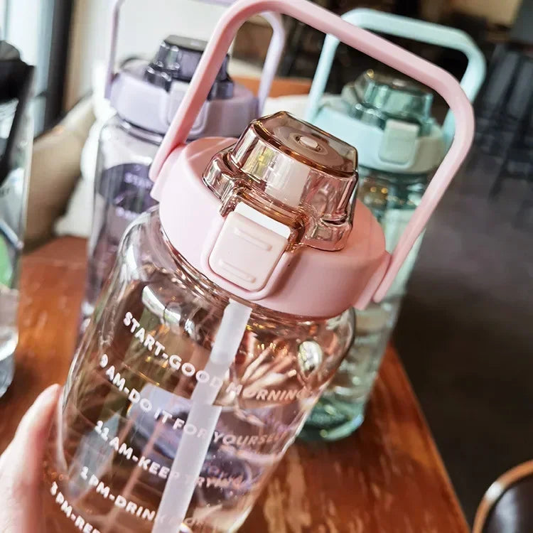 Transparente Wasserflasche mit rosa Deckel, Zeitmarkierungen, BPA-frei, 1 Liter, Kunststoff.