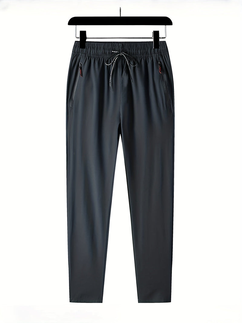 Dunkelgraue Jogginghose, elastischer Bund, Kordelzug, Reißverschlusstaschen, Herrenmode.