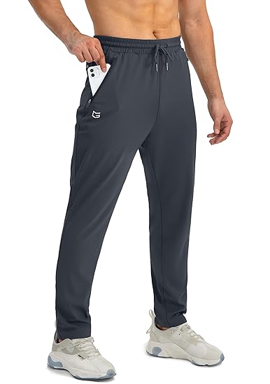 Mann in grauer Jogginghose mit Smartphone in der Tasche, Sportbekleidung, Fitnessmode.