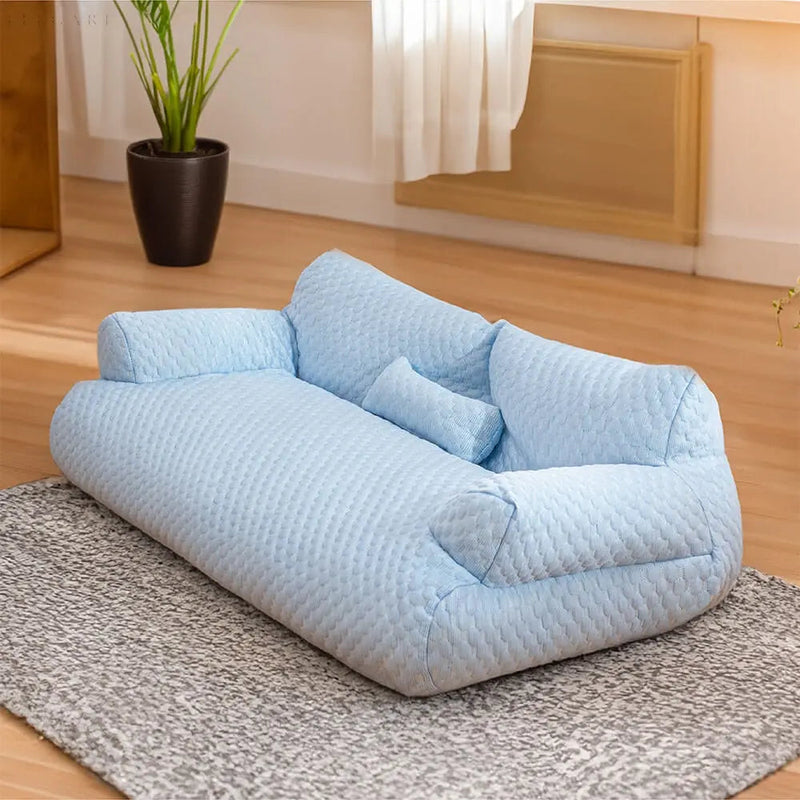 Hellblaues, waschbares Plüsch-Tierbett auf grauem Teppich, ideal für Haustiere.