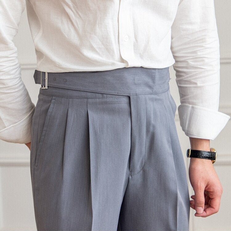Mann in weißem Hemd und grauer Anzughose mit Gürtel, Businessmode, elegante Herrenbekleidung.