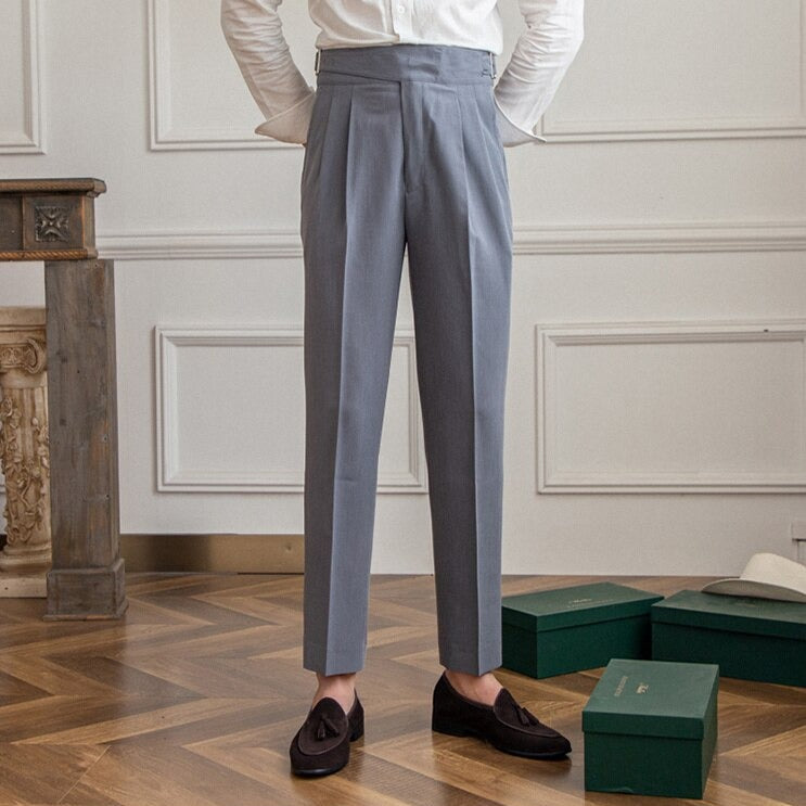 Graue Herrenanzughose, elegant, aus Wolle, mit Falten, getragen mit braunen Loafern, Holzboden.