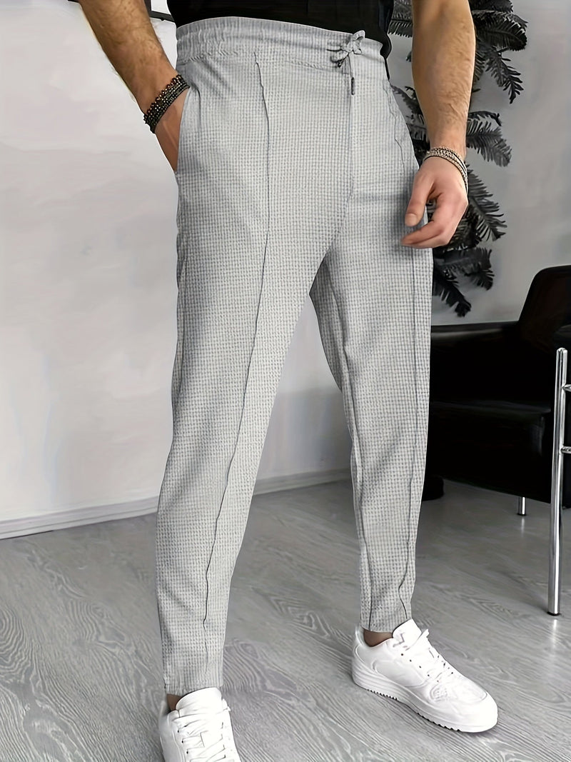 Graue karierte Herren-Chinohose, elastischer Bund, modern, stilvoll, Freizeitmode.