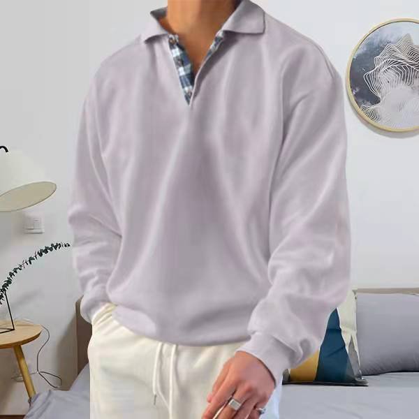Mann in weißem Pullover und Hose im Wohnzimmer, moderne Einrichtung, stilvolle Mode.