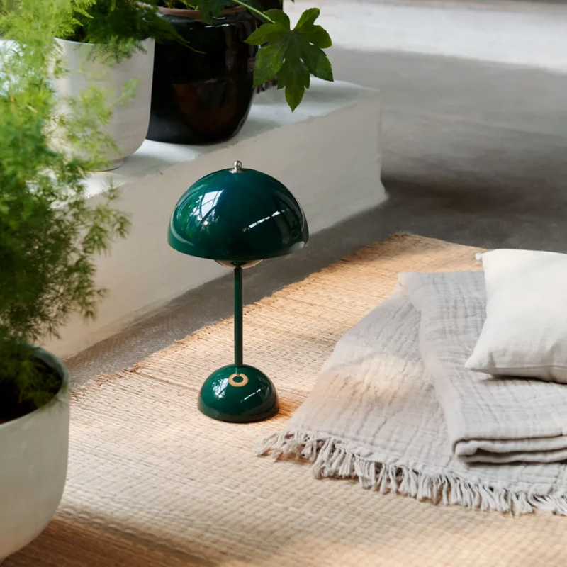 Grüne Tischlampe auf Teppich, modernes Design, Wohnzimmerdekoration, skandinavischer Stil.