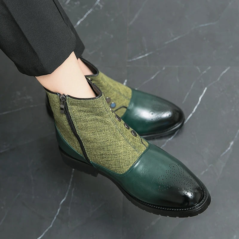 Grüne Herrenstiefel aus Leder und Stoff mit Reißverschluss, elegantes Design, auf Marmorboden.