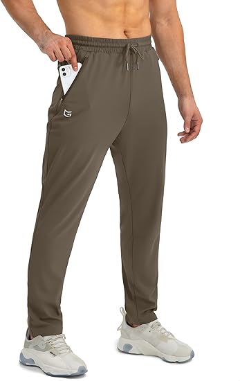 Mann in olivgrüner Jogginghose mit Smartphone in der Tasche, sportlich, bequem, modern.