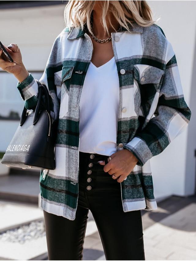 Frau in kariertem Hemdjacke, weißem T-Shirt, Lederhose, hält schwarze Handtasche.