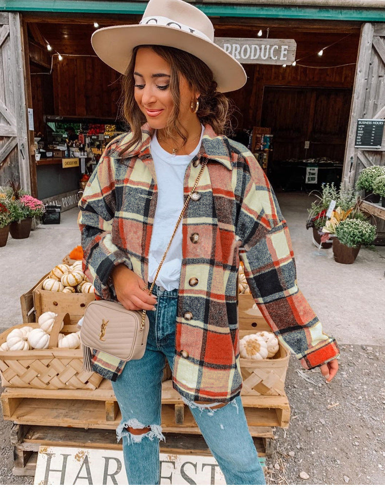 Frau in karierter Jacke und Hut vor Bauernmarkt mit Kürbissen, Jeans, Umhängetasche.
