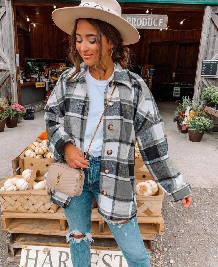 Frau in kariertem Mantel und Hut vor Bauernmarkt, Herbstmode, lässiger Stil, Jeans, Handtasche.