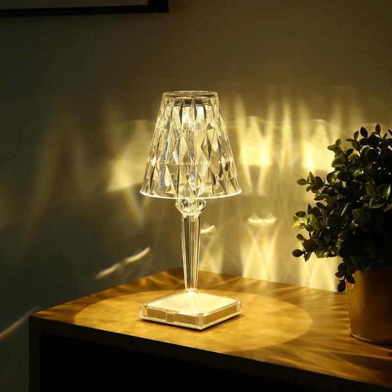 Kristall-Tischlampe mit LED-Beleuchtung, transparent, modernes Design, auf Holzoberfläche.