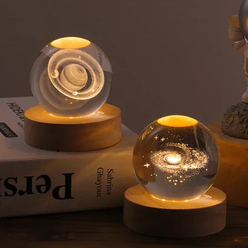 Kristallkugel mit Galaxie-Design auf Holzsockel, dekorative LED-Lampe, warmes Licht.