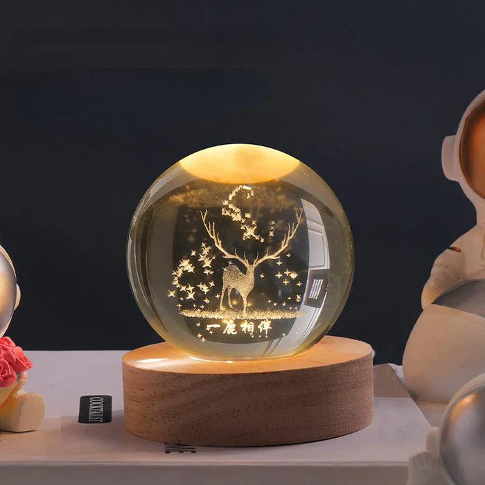 Kristallkugel mit Hirschgravur auf Holzsockel, dekorative LED-Lampe, warmes Licht.