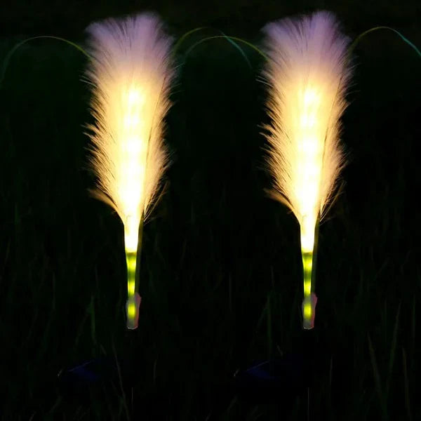 Zwei leuchtende LED-Gartenlichter in Federform, warmweiß, für Außenbereich, Nachtdekoration.
