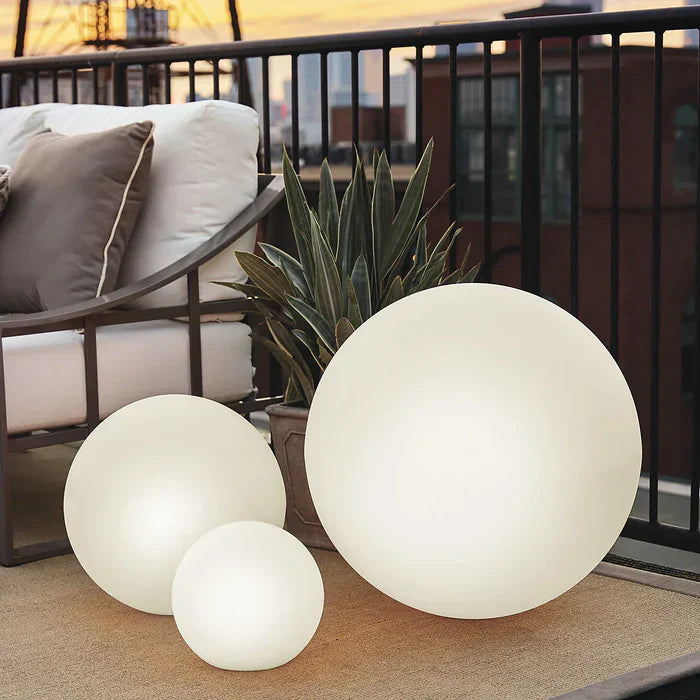 Drei runde LED-Leuchtkugeln auf Balkon, moderne Außenbeleuchtung, energiesparend, stilvoll.