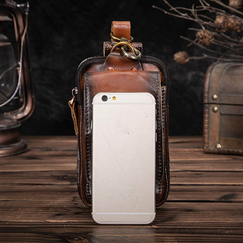 Braune Herren-Gürteltasche aus Leder, vintage Stil, mit Smartphone, auf Holztisch.