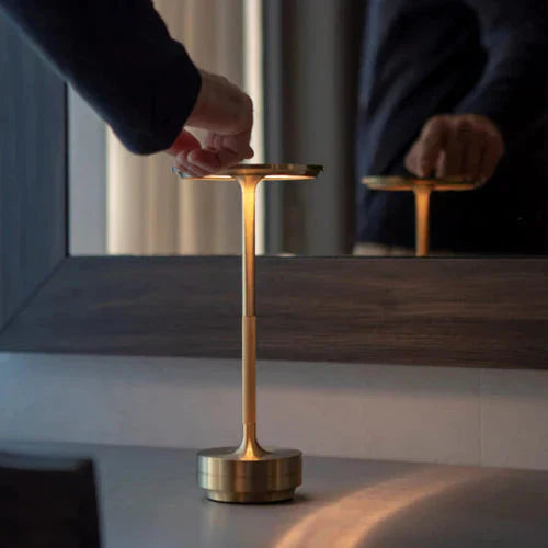 Goldene Metall-Touchlampe auf Tisch, modernes Design, ideal für stilvolle Innenbeleuchtung.