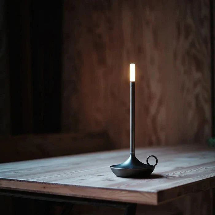 Moderne schwarze LED-Tischlampe auf Holztisch, minimalistisches Design, stimmungsvolle Beleuchtung.