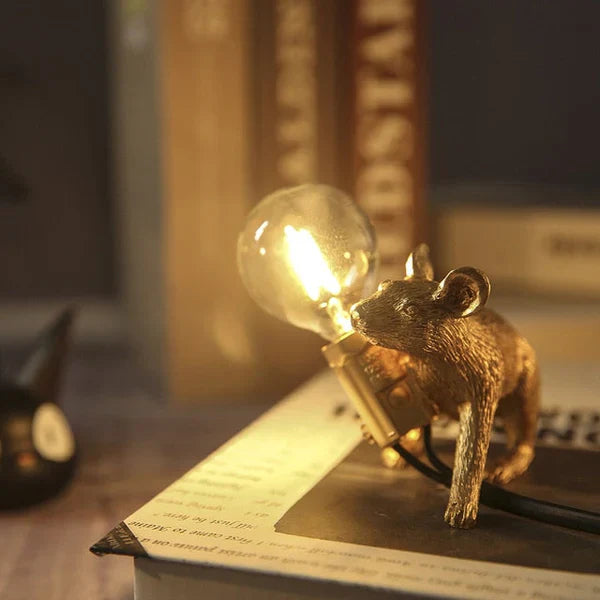 Goldene Mauslampe mit Glühbirne, dekorative Tischleuchte, Vintage-Stil, warmes Licht.