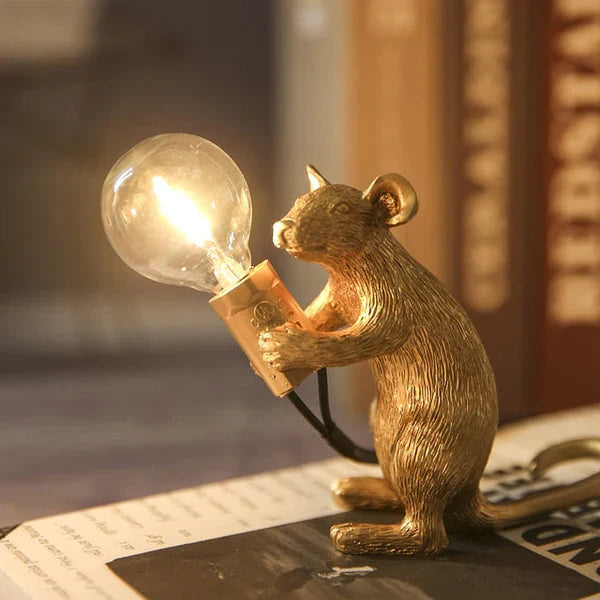 Goldene Mauslampe mit Glühbirne, dekorative Tischleuchte, Vintage-Stil, warmes Licht.