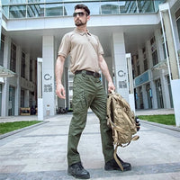 Mann in taktischer Kleidung mit Rucksack vor modernem Gebäude, Outdoor-Ausrüstung, urbaner Stil.