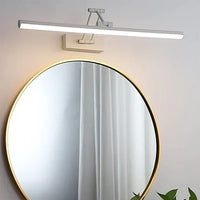 Runder Spiegel mit goldfarbenem Rand und moderner LED-Wandleuchte in minimalistischem Design.