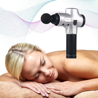 Silberne Massagepistole, kabellos, zur Muskelentspannung, auf entspanntem Model angewendet.