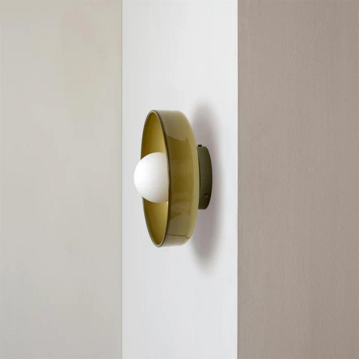 Moderne Wandleuchte aus grünem Glas mit weißem Leuchtmittel, minimalistisches Design.