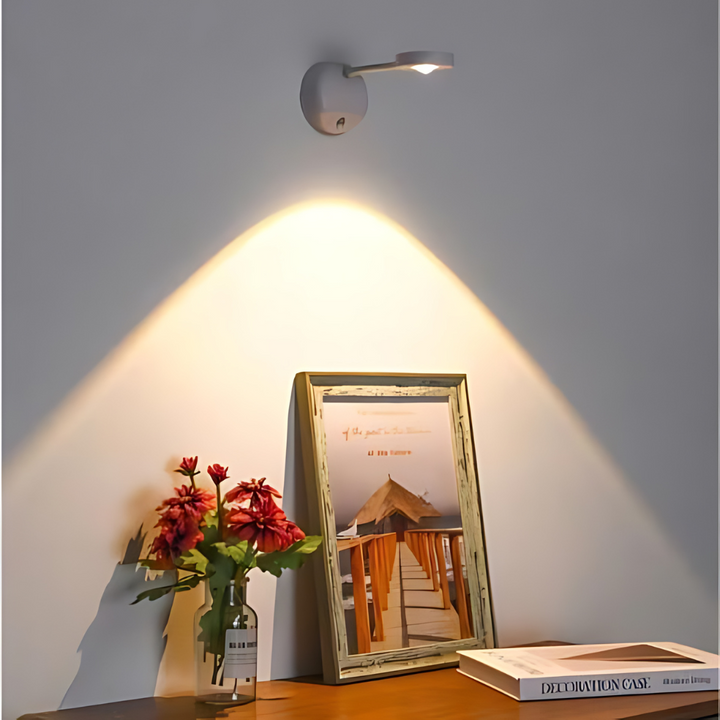 Moderne LED-Wandleuchte in Weiß beleuchtet Bild und Blumen auf Holztisch.